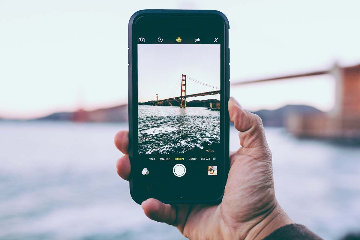 fort point person taking photo of Golden Gate Bridge, California iphone